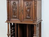 a tall wooden cabinet with carvings on the top of it