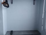 a small room with a metal shelf and a shelf on the wall