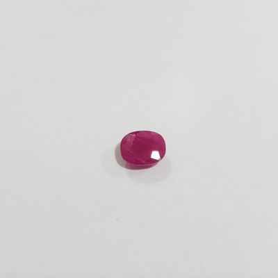 a pink sapphire stone on a white surface