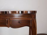 a small wooden table with two drawers on it