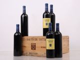 trois bouteilles de vin sont posées à côté d'une caisse en bois sur une table