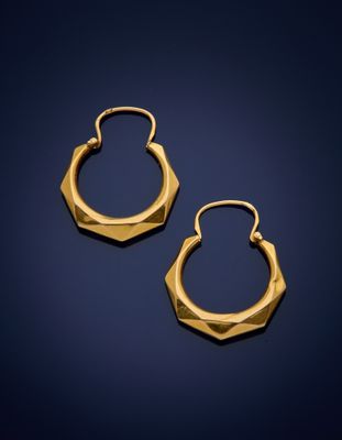 a pair of gold hoop earrings on a blue background