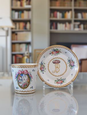 une tasse et une soucoupe posées sur une table devant une bibliothèque