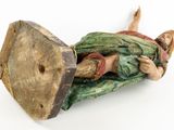 a figurine of a man laying on a wooden block