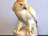 une figurine représentant un cacatoès posé sur un rocher