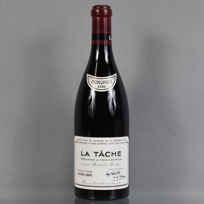a bottle of wine sitting on top of a table next to a glass