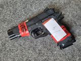 a gun with a tag on it laying on a carpet