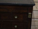 a wooden dresser with a black top and brass knobs on it