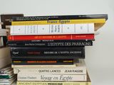 many books stacked on top of each other on a table
