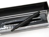 un stylo dans une boîte transparente posée sur une surface blanche