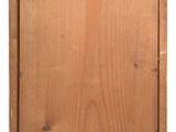 an old wooden box with a label on it sitting on a white surface