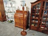 une grande armoire en bois surmontée d'une lampe, à côté d'une grande armoire en bois dotée d'une porte vitrée