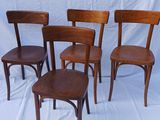 quatre chaises en bois sont alignées sur un fond blanc