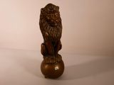 une statue représentant un lion assis sur une boule