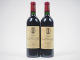deux bouteilles de vin rouge posées l'une à côté de l'autre sur une surface blanche