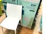 une chaise blanche posée à côté d'une boîte