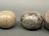 four different types of wooden balls are lined up on a table