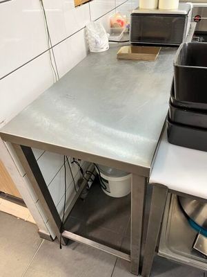 une petite cuisine avec une cuisinière et un micro-ondes posés sur le plan de travail