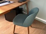 un bureau avec un écran d'ordinateur et une chaise devant