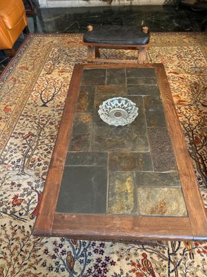 une table basse avec un plateau en verre posée sur un tapis