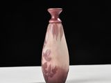a pink vase sitting on a white table with a black background