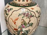 a vase that has a bird on it in a glass case