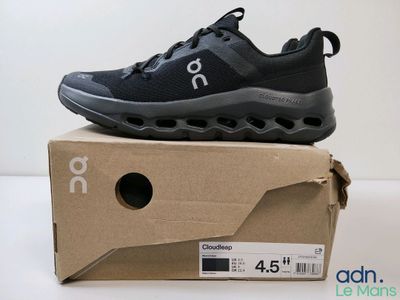 des chaussures de course posées sur une boîte en carton, sur une surface blanche