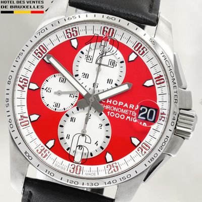 a close up of a watch with a red face
