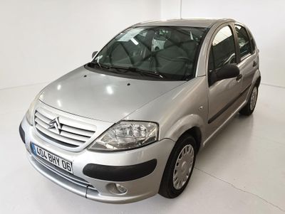 une voiture argentée garée dans une pièce blanche