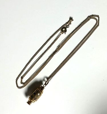 a necklace that has a small bird on it