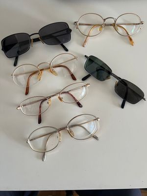 several pairs of glasses sitting on top of a table next to each other