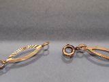 two pairs of gold earrings with a leaf design on them