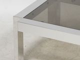 a glass coffee table with a metal base and a glass top