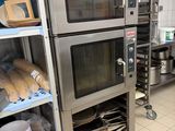 several ovens are stacked on shelves in a commercial kitchen