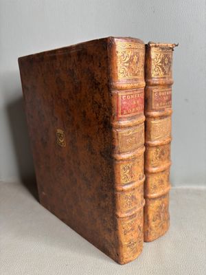 two old books sitting on top of each other on a table