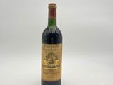 une vieille bouteille de vin posée sur une surface blanche