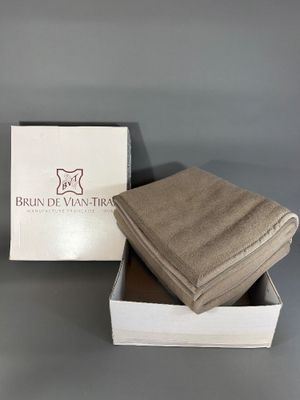 two folded towels in a white box on a gray surface