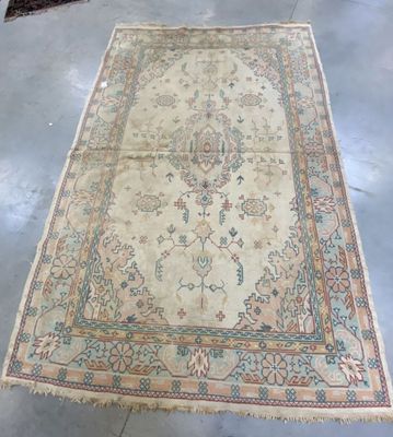 Il y a un vieux tapis par terre dans une pièce.