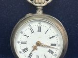 une montre de poche en argent avec des chiffres romains