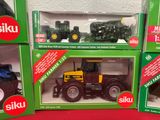 four boxes of toy tractors on a red surface