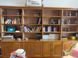 a book shelf with many books on it in a living room