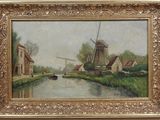 an oil painting of a windmill and a canal in a gold frame