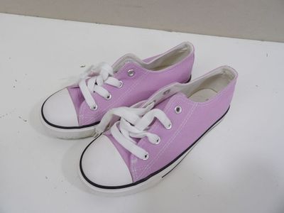 des Converse violettes et blanches avec des lacets blancs sur un fond blanc