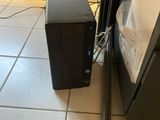 a small black computer on the floor next to a metal pole