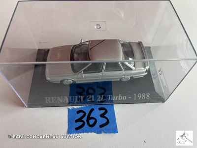 une petite voiture miniature dans une boîte transparente posée sur une table