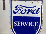 an old blue and white ford service sign sitting on top of a table