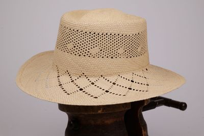un chapeau de paille posé sur un vase