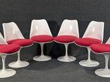 six chaises « Tulip » avec des coussins rouges et des piètements blancs