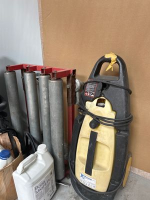 un aspirateur jaune et noir posé à côté d'un tas d'objets divers