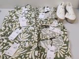 un tas de vêtements posé sur une table, à côté d'une paire de chaussures
